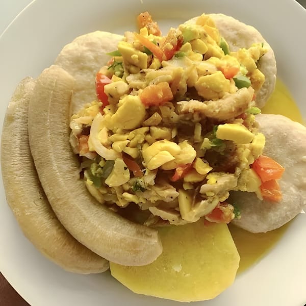 A plate of Island Crave's ackee and saltfish with boiled bananas, dumplings, and yellow yam.